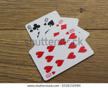poker cards on a wooden backround, set of ten of clubs, diamonds, spades, and hearts