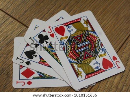 poker cards on a wooden backround, set of jacks of clubs, diamonds, spades, and hearts