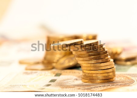 beautiful golden coins lying in a pile on paper bills, close-up photos, coins leaned and can fall on other money