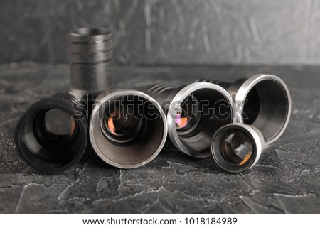 Old lenses on a dark concrete background. Black texture of cement.