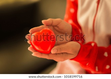 Close up red heart in hands of woman,Warm tone picture