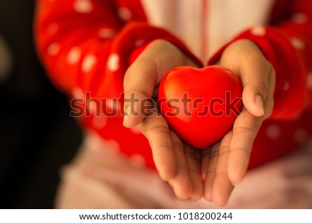 Close up woman hands giving red heart,Warm tone picture