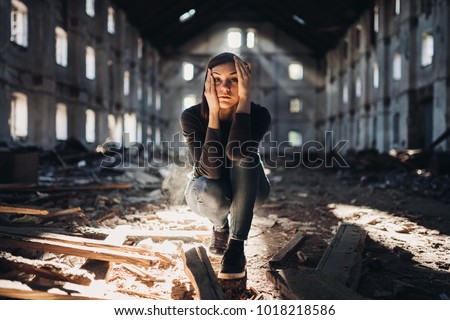 Sad depressed person in abandoned destroyed building crying.Emotional portrait.Raped woman victim of domestic violence.Human trafficking and kidnapping.Scared and worried woman 