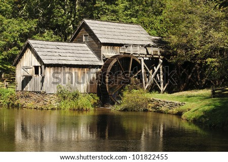 A wooden water mill with a lake
