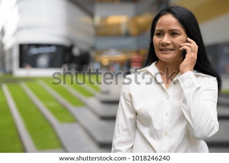 Portrait of mature beautiful Asian businesswoman exploring the city of Bangkok, Thailand