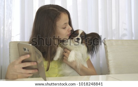 Happy teenage girl doing selfie with a her dog
