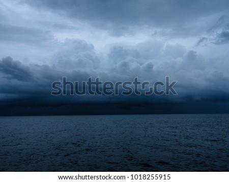 Dark & Dramatic blue sky and dark & Dramatic blue sea color and dark storm raining cloud background. Royalty-Free Stock Photo #1018255915
