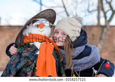 Happy young girl with a snowman, close up. Ukraine