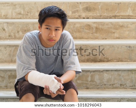 Asian boy with broken arm To wear a splint Because of accident By playing sports
