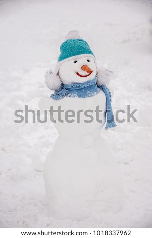 Snowman at the children's winter festival, dressed in clothes and hats
