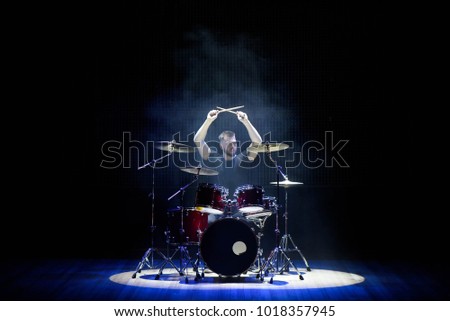 Drummer playing the drums with smoke and powder in the background