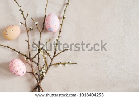 Easter background in beige color with spring flowering branches and easter eggs. Top view, copy space. Royalty-Free Stock Photo #1018404253