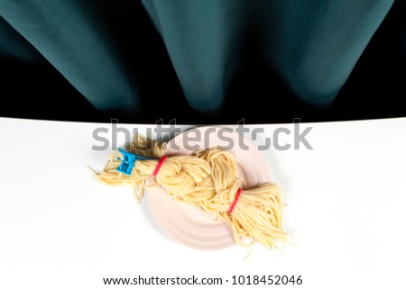 a delicious italian buttered spaghetti meal presented in a pink plate as blond braided hair. Minimal funny and quirky pop still life photography 