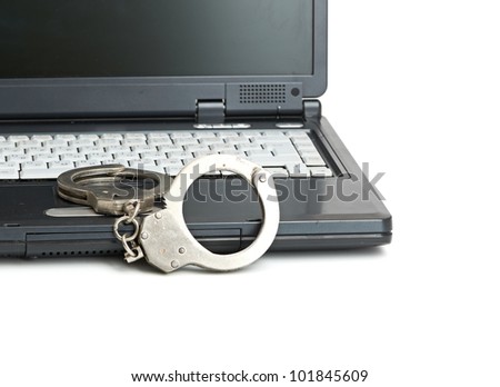 Handcuffs is on the laptop keyboard. Computer/Internet crimes and internet addiction concept. Royalty-Free Stock Photo #101845609