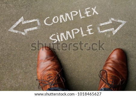 Top view of the words Complex and Simple with arrows pointing into opposite directions Royalty-Free Stock Photo #1018465627