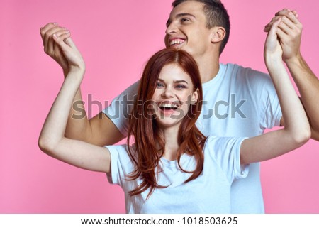 happy young couple on a pink background                               