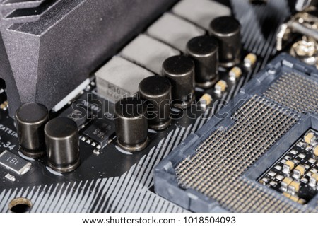 Close up on the cpu socket of a modern computer mainboard - focus on the surrounding capacitors.
