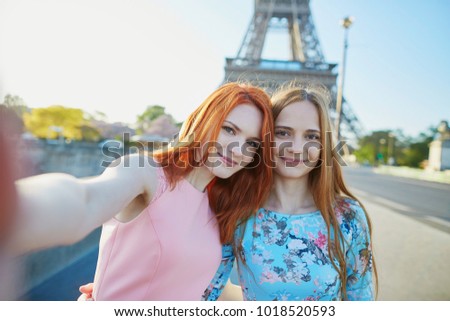 Two friends taking selfie near the Eiffel tower in Paris, France
