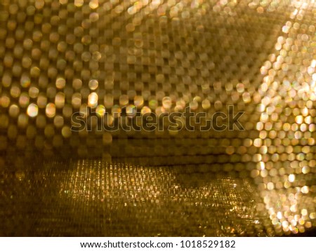 Gold mesh net with focus and shallow depto fo field, gold bokeh net pattern
