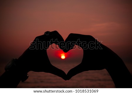 hands in shape of love heart with background sky on sunset, love concept. Valentines's day.