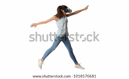 Pretty cute excited female in VR headset looking up and trying to touch objects in virtual reality