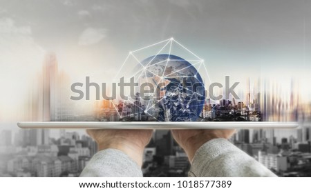 Hand holding digital tablet with global network connection technology and modern buildings. Element of this image are furnished by NASA Royalty-Free Stock Photo #1018577389