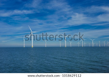 Offshore Windmill farm in the ocean  Westermeerwind park , windmills isolated at sea on a beautiful bright day Netherlands Flevoland Noordoostpolder Royalty-Free Stock Photo #1018629112