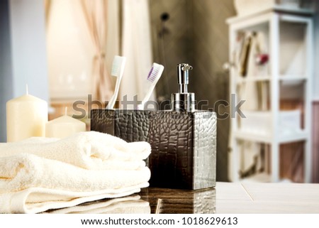 Table background of free space for your product and blurreed interior of bathroom. Towels decoration on top. 