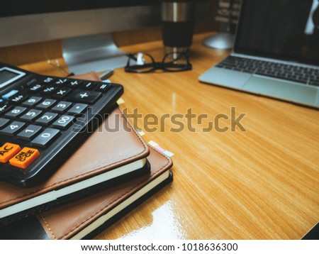 Office desk wood table of Business workplace and business objects.Open notebook tablet computer glasses calculater paperwork book and accessories  on the office table.Office workplace concept