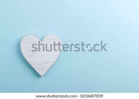 White wooden heart on blue cardboard background