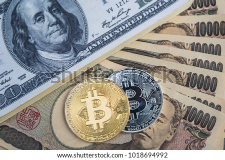 Exchange bitcoin for a dollar and Japanese yen banknotes. Conceptual image for worldwide cryptocurrency and digital payment system.