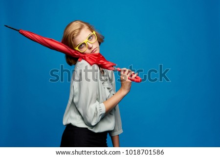  woman in glasses holds a red umbrella on a blue background                              