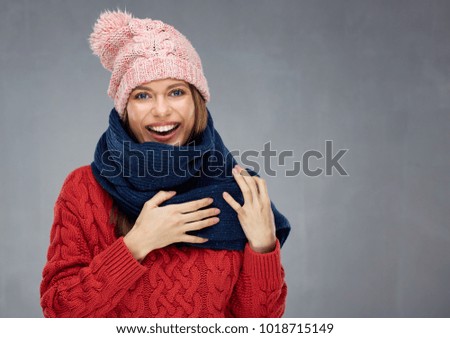 Smiling woman wearing knitted sweater, winter scarf and cup. Isolated portrait.