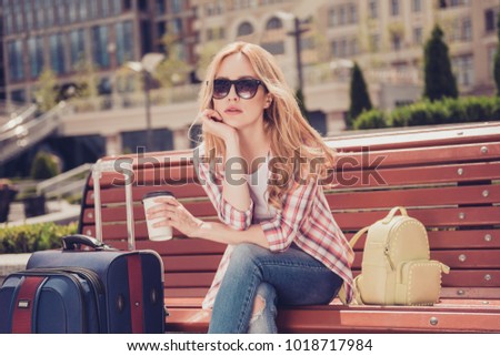 Taxi transtort searching customs abroad concept. Upset bored unhappy beautiful woman with long blonde wavy hair checkered shirt ripped jeans sitting waiting for plane arriving