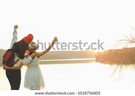 Two pretty girls backpack in nature, Raise your arms to convey success after reaching destination. Relax time on holiday and freedom life concept. Selective and soft focus, tone of hipster style.