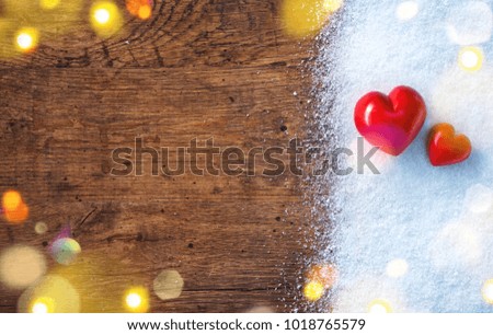 Two red hearts on snow and rustic background. Love and St. Valentines Day concept.