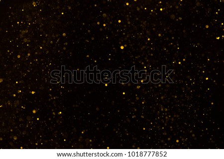 Golden glitter falling sparkle background on black