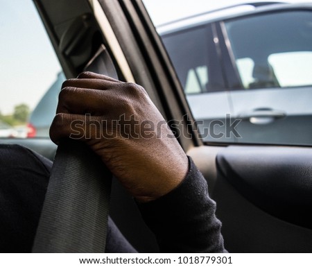 Dark brown skin African woman's hand pulling and wearing safety seatbelt in the car automobile accident safety concept Royalty-Free Stock Photo #1018779301