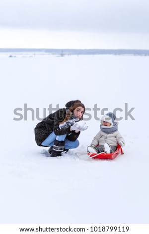 Winter baby girl and mother. Toddler kid and woman on the snow natures. Winter clothing