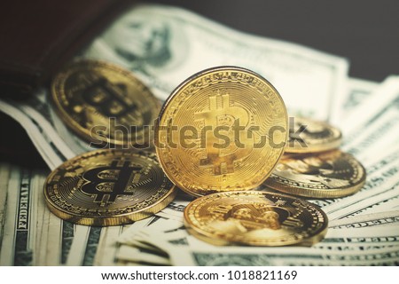 gold bitcoin, on top of dollar stack.