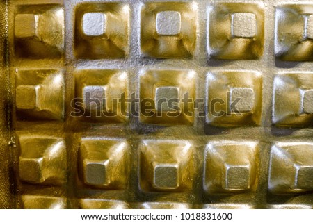 Golden bulging pyramids on the wall, background.