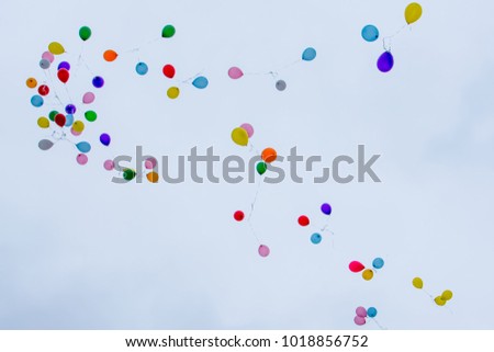 A lot of multi-colored balloons into the sky. Colorful flying balloons.