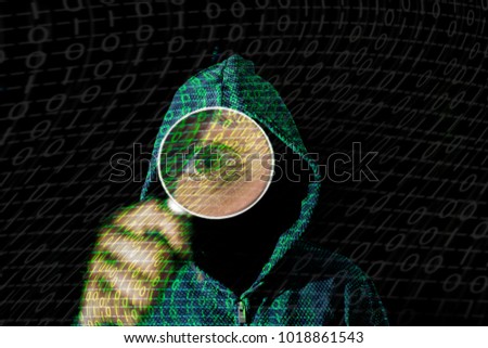Young hacker in data security concept on a dark background  with magnifying glass in hand
