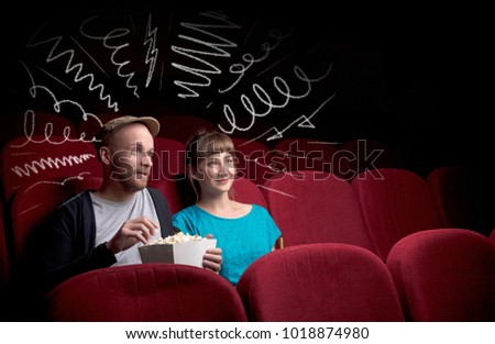 Young cute couple sitting in cinema, and eating popcorn while watching movie with doodle graphics
