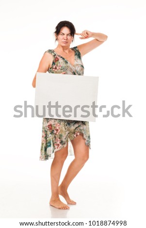 A beautiful woman in a dress holds a white billboard in her hands for advertising, logo, business cards, stock. White card, banner. High model- the brunette shows the wounded poses and emotions.