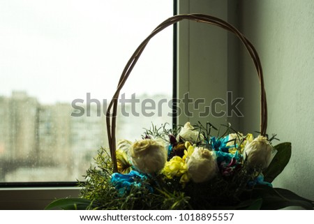 a basket with flowers on the window