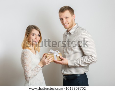 young couple giving gifts to each other, congratulations on the day of all lovers, concept of the holy Valentine, in the studio on a white background