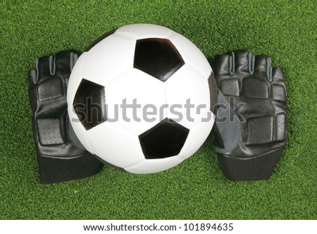 Soccer ball with glove on green grass