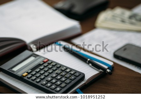 Budget planing concept. Calculating of bills, taxes, credits, payments and debts, paperwork with notebooks and calculator for expenses and finance. Selective focus