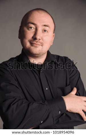 Colored portrait of handsome smiling man isolated on gray studio background posing to the camera